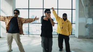 Çok kültürlü hipster grubu kameraya bakarken gökyüzü avcısıyla ya da şehir manzaralı bir binada break dans yapıyorlar. Sokak dansçısı ekibi dansçı performansına bakıyor. Açık hava sporu 2024 hiphop..