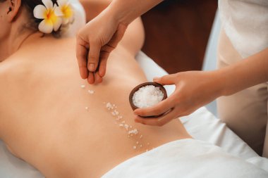 Lüks spa salonlarında sıcak mum ışığında cilt bakımı yaptıran kadın müşteri. Sağlık Spa vücut fırçasında tuz temizleme güzellik tedavisi. Sessiz.