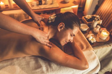 Beyaz kadın müşteri stres önleyici spa masajının keyfini çıkarıyor ve lüks otel ya da otelde sıcak mum ışığında güzellik teniyle eğleniyor. Sessiz.