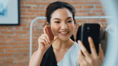 Kadın nüfuzlu kişi canlı yayın yapan video görüntülerini sosyal medya ya da blog üzerinden gözden geçiriyor. Kozmetik stüdyosu ışıklandırmalı mutlu genç kız çevrimiçi pazarlama oturumu yayını için..