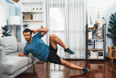 Atletik vücut ve aktif sporcu, sağlıklı vücut çalışma yaşam tarzı konsepti olarak neşeli ev egzersizlerinde kas kazanma egzersizi yapmak için mobilyaları kullanıyor..