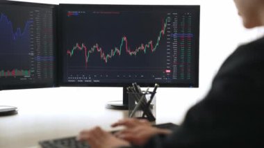 Menkul kıymetler borsası pazarlamasını inceleyen borsa yatırımcıları, zarar ve kazanç için mum bar fiyatlarını analiz eden monitörlere bakıyor. Filizlenen