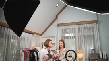 Etkilenen iki ortak canlı yayında video görüntülerini çekiyor makyaj malzemesi prim sosyal medya veya blog. Kozmetik stüdyosu ışıklandırmalı mutlu genç kız çevrimiçi pazarlama oturumu yayını için..
