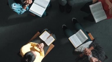 Yetenekli çeşitli duaların el ele tutuşması ve daireler çizerek Tanrı 'ya dua edişinin üst görüntüsü. Kucaklarda açık incille otururken el ele tutuşan insanların yukarıdan aşağı hava görüntüsü. Sempozyum.