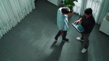 Elinde tablet varken yatırımcıya doğru yürüyen ve mali istatistiklere bakan bir iş adamı. Lider tabletteki hisse senedi piyasasının artması hakkında bilgi veriyor. Cemaat.