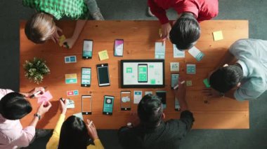 Ux ui tasarımını renkli yapışkan nota üzerine yazmak için birlikte çalışan geliştirici ekibinin üst görüşü. Tablet 'te kablo prototipi inceleyen ve yazılım tasarlayan bir grup programcı. Cemaat.