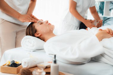 Kaplıca salonunun sakin, modern gündüz atmosferi, birkaç müşteri yüz maskesi takarak kendini yenilemeye çalışıyor. Yüz bakımı ve güzellik kozmetolojisi prosedürü. Sessiz.