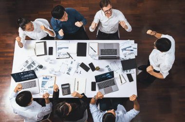 Üst düzey toplantı masası, heyecanlı ve mutlu ofis çalışanı başarılı bir stratejik pazarlama planlamasından sonra kutlama yapıyor. Takım çalışması ve olumlu tutum verimli bir işyeri yaratır. Tedbirli