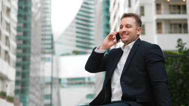 Kafkasyalı işadamı, müdürle telefonda plan stratejisi hakkında konuşurken bankta oturuyor. Profesyonel yönetici pazarlama ekibini arıyor ve şehirde yaratıcı fikirleri paylaşıyor. Urbane.