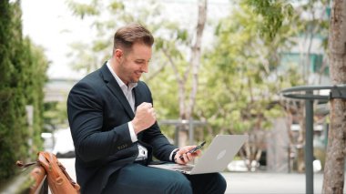 Kafkasyalı iş adamları Green City 'de otururken telefonla konuşuyor. Happy proje yöneticisi başarılı bir projeyi kutluyor ya da parkta dizüstü bilgisayarla çalışırken telefondan iyi haberler alıyor. Urbane.