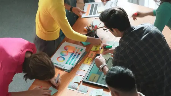 经理在贴纸上写想法的最高视图 并解释网页设计的想法 专业的营销团队或程序员在使用彩色调色板观看平板电脑时头脑风暴的想法 专题讨论会 — 图库照片