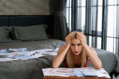 Stresli genç kadın, mali borç sorunu, aylık giderleri ve kredi kartı borçlarıyla İnternet üzerinden faturalarını öderken masada oturuyor. Para harcamak yaşam tarzı sorunu yüzünden. Blithe