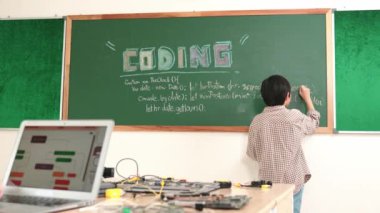 Kız, yazılım geliştirme planı yazarken yapay zeka yazılımı ya da programlama sistemini kullanarak kök sınıftaki elektronik ana tahtada yapay zeka üretiyor. Pedagoji.