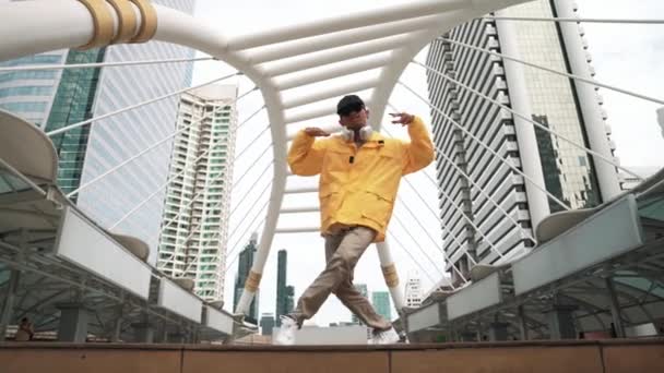 亚洲嬉皮士的低角度相机在戴耳机时练习跳霹雳脚步声或男声表演 自由式舞 霹雳舞 街头舞 心情真好2024年户外运动 神气活现 — 图库视频影像
