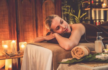 Beyaz kadın müşteri stres önleyici spa masajının keyfini çıkarıyor ve lüks otel ya da otelde sıcak mum ışığında güzellik teniyle eğleniyor. Sessiz.