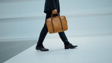 Profesyonel iş adamının bacağını tutarken yakın plan fotoğrafı. Proje yöneticisinin bacağa odaklanmış görüntüsü. Seyahat, taşınma, yolculuk, yürüyüş, yeni bir pozisyon alma, iş değiştirme. Sevinçli..