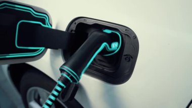 Fütürist EV şarj cihazıyla elektrikli araba şarj istasyonundan şarj oluyor. EV arabaların son teknoloji gelişimi ve sürdürülebilir enerji için akıllı ev yenilenebilir enerji altyapısı. İnceleyin