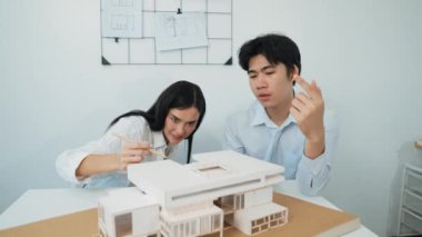 Profesyonel akıllı iş birliği mühendisi mühendis ekibi modern ofisteki ev yapısını planla kontrol ederken genç ve güzel proje yöneticisi not alıyor. Yaratıcı tasarım konsepti. Tertemiz...