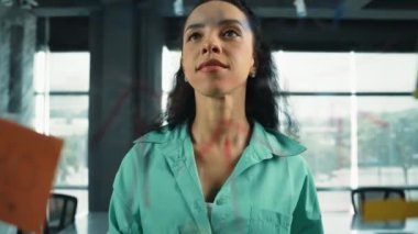 Zeki profesyonel İspanyol iş kadını renkli yapışkan notlarla cam tahtaya pazarlama fikirleri yazıyor. Genç çekici yönetici, analiz iş planının zihin haritasını çiziyor. - Yakın çekim. Yönlendirici.