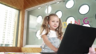Başarı projesini kutlamak için elini kaldırırken dizüstü bilgisayar ekranına bakan mutlu kız. Öğrenciler yazmayı, programlamayı ve STEM teknoloji sınıfında mutlulukla bağırmayı bitirdiler. Etkinlik.