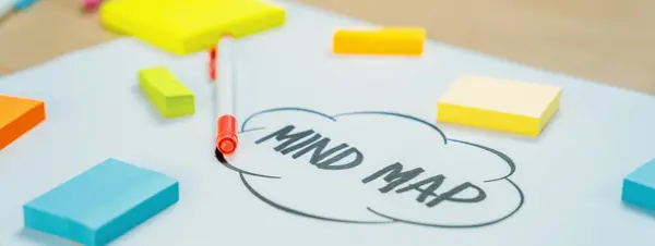 Business marketing strategy and brain storming mind map, colorful sticky notes and equipment placed on table at modern workplace. Creativity startup and marketing plan concept. Closeup. Variegated.