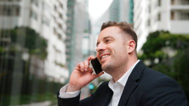 İş adamı, geçmişi bulanık bir telefonla finansal strateji hakkında yöneticiyle konuşuyor. Proje yöneticisi yatırımcıyı arıyor ve bulanık arkaplanlı pazarlama fikrini sunuyor. Yaşam tarzı. Urbane.