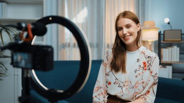 Kadın nüfuzlu kişi video görüntülerini canlı yayınlıyor. Kıyafetler sosyal medyada ya da blogda yer alıyor. Stüdyo ışıklandırmalı mutlu genç kız çevrimiçi pazarlama oturumu yayını için..