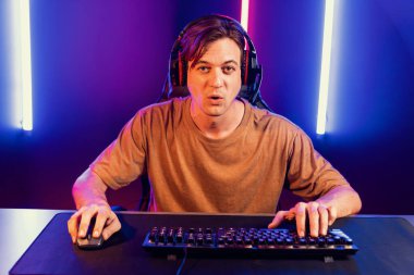 Kazanmak için çevrimiçi oyun oynayan akıllı flama makinesinin sunucu kanalı, neon ışıklı odada seçilen takım yarışması için izleyicilerle birlikte canlı yayında canlı yayında kulaklık takıyor. Bireysel.