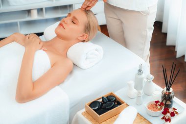 Kafkasyalı kadın stres önleyici kafa masajından ve lüks tatil beldesi ya da otel spa salonundaki modern ışık ortamında yüz güzelliği eğlencelerini şımartmaktan hoşlanıyor. Sessiz.