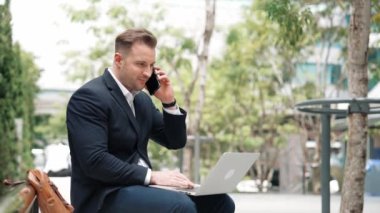 Kafkasyalı iş adamları Green City 'de otururken telefonla konuşuyor. Happy proje yöneticisi başarılı bir projeyi kutluyor ya da parkta dizüstü bilgisayarla çalışırken telefondan iyi haberler alıyor. Urbane.