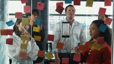 Mutlu iş adamları cam duvarda başarılı bir projeyi kutluyor. Profesyonel iş adamlarından oluşan bir grup el sıkışıyor, beşlik çakıyor, iş toplantısında başparmağını kaldırıyor. Yaratıcı iş. Yönlendirici.