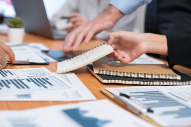 Ofis masasındaki finansal veri raporlarını analiz eden çeşitli bir grup iş analisti. Stratejik pazarlama planlaması için iş istihbarat analizine göre grafikler ve grafikler.