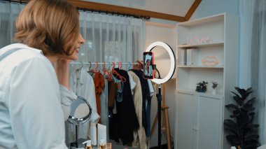 Arka plan etkileyicisi, vlog video gözden geçirme makyaj primi sosyal medya ya da blog kullanarak akıllı telefon yayınıyla canlı çekim yapıyor. İnternetteki pazarlama kaydı için kozmetik stüdyosu ışıklandırması olan kız.