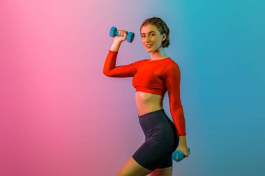 Vücut geliştirme egzersizi olarak izole edilmiş arka planda duran vücut geliştirme egzersizi olarak ağırlık kaldırmak için halterli atletik ve sportif bir kadın. Sağlıklı aktif ve vücut bakımı yaşam tarzı