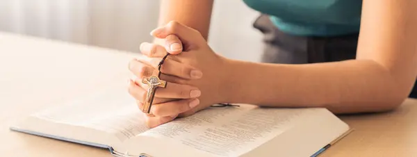 Imagem Recortada Fêmea Lendo Livro Bíblico Enquanto Segurava Cruz Mesa — Fotografia de Stock