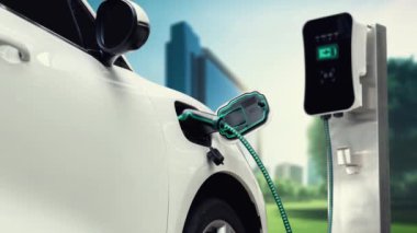 Yeşil Şehir Parkı 'ndaki ekolojik temiz enerji şarj istasyonundan gelen fütürist akıllı EV şarj aletinin şarj ettiği elektrikli araba. Alternatif enerji kullanan gelecekçi elektrikli araba. İnceleyin