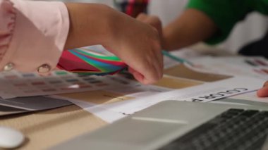 Grafik tasarımı için renk seçimi yapan ve beyin fırtınası yapan iki tasarımcının yavaş çekim çekimi ya da tasarım bürosunda kromatik danışmanlık hizmeti isteyen bir müşteri. Değiştirilmiş