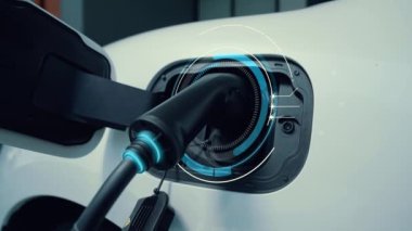 Elektrikli araba, gelecekteki ev şarj istasyonunda akıllı dijital EV batarya durumu hologramıyla şarj oluyor. EV arabasının teknolojik gelişimi ve sürdürülebilir gelecek için ev enerjisi altyapısı. İncelenme