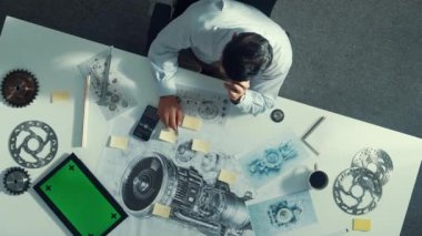 Türbin motoru veya jet motoru tasarımı ve çeşitli metal teçhizat dağılımı ile toplantı masasında yeşil ekranlı tablet üzerinde çalışırken telefona bakan mühendis görüntüsü. Hizalama.