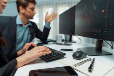 İki tüccar, dinamik borsada döviz oranı yatırım programı web sitesini iki bilgisayar ekranında analiz ediyor. Modern ofisteki gerçek zamanlı grafiği karşılaştırmak isteyen bir kadın. Varsayım.