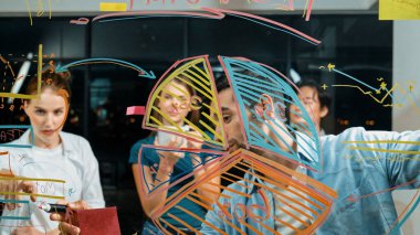 Yetenekli erkek lider, istatistik grafiğini uzman yatırımcılara açıklıyor. Akıllı iş adamı sunar, finans planlarını gece ofisindeki cam duvardaki yatırımcılara gösterir. İş konsepti. İzleme