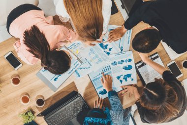 Modern ofisteki iş adamları ve iş kadınlarıyla grup toplantısındaki iş adamlarının en üst düzey görüşü, masada dizüstü bilgisayar, kahve ve belge ile. Kurumsal şirketler uds