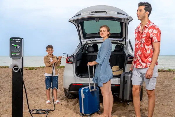 電気自動車でビーチで旅行する家族の休暇旅行 クリーンエネルギーでEvカーバッテリーを充電しながら 素敵な家族 環境に優しい車による代替家族旅行 — ストック写真