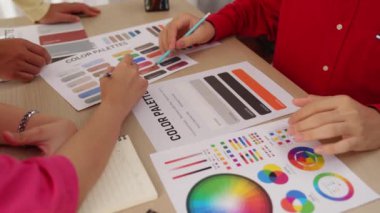 Grafik tasarımı için beyin fırtınası yapan ve renk seçimi yapan tasarımcı ekibinin yavaş çekim çekimi veya tasarım bürosunda krom danışmanlığı için danışmanlık isteyen bir müşteri. Değiştirilmiş