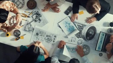 Türbin motoru tasarlamak için çalışan akıllı mühendis takımının yukarıdan aşağıya hava görüntüsü. Profesyonel teknisyen jet motoru yapımını tartışırken motorun bir kısmını işaret ediyor. Hizalama.