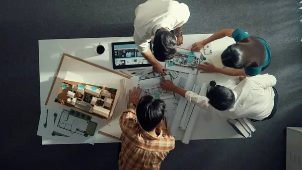 Top down view of smart architect engineer measure blueprint by using architectural equipment while group of designer talking about building design or house construction at meeting room. Alimentation.