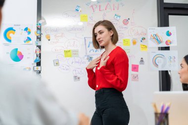 Profesyonel çekici kadın lider, modern iş toplantı odasında beyin fırtınası zihin haritalama istatistikleri ve renkli yapışkan notlar kullanarak yaratıcı pazarlama planını sunuyor. Tertemiz..