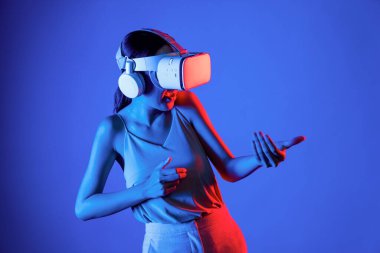 VR kulaklık takan zeki bir kadın metaevrene bağlanıyor, gelecekteki siber uzay topluluğu teknolojisi. Sanal silaha hükmeden zarif bir kadın ciddi ciddi oyun oynuyor. Halüsinasyon.