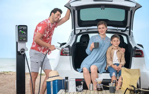 電気自動車でビーチで旅行する家族旅行 幸せな家族の再充電Ev車 屋外キャンプコーヒーを楽しむ きれいな環境のための海岸の旅行そして環境に優しい車 パーペチュアル — ストック写真