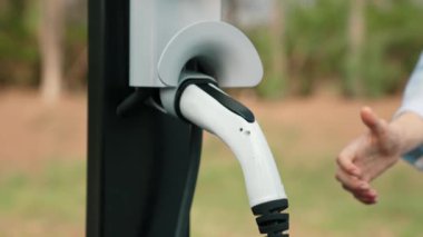 Otomobil seyahati sırasında elektrikli araba için şarj olan kadın Autumanl sezonunda doğal orman ya da milli parkta. Tatil ve tatil boyunca çevre dostu seyahat. Yükselt